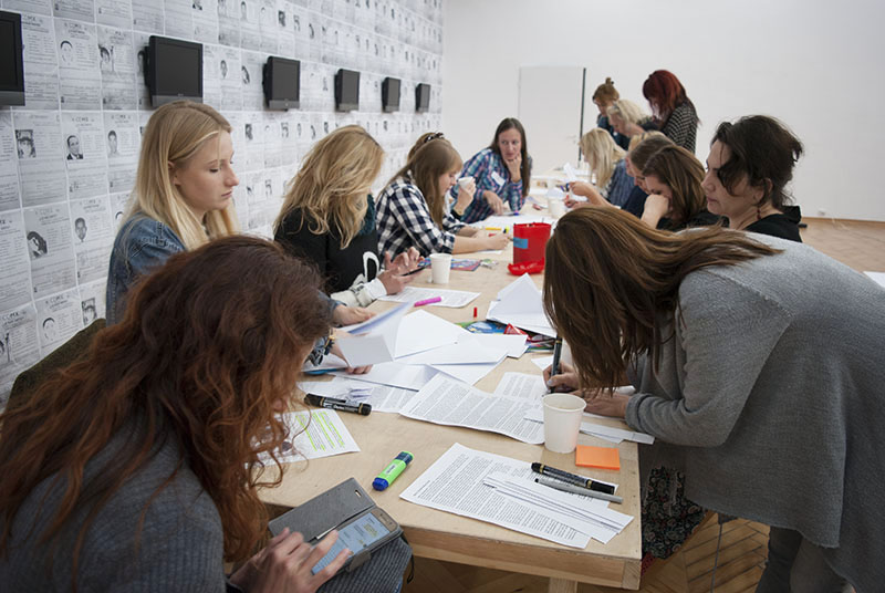 Na fotografii - grupa kobiet pracująca z notatkami przy długim stole.